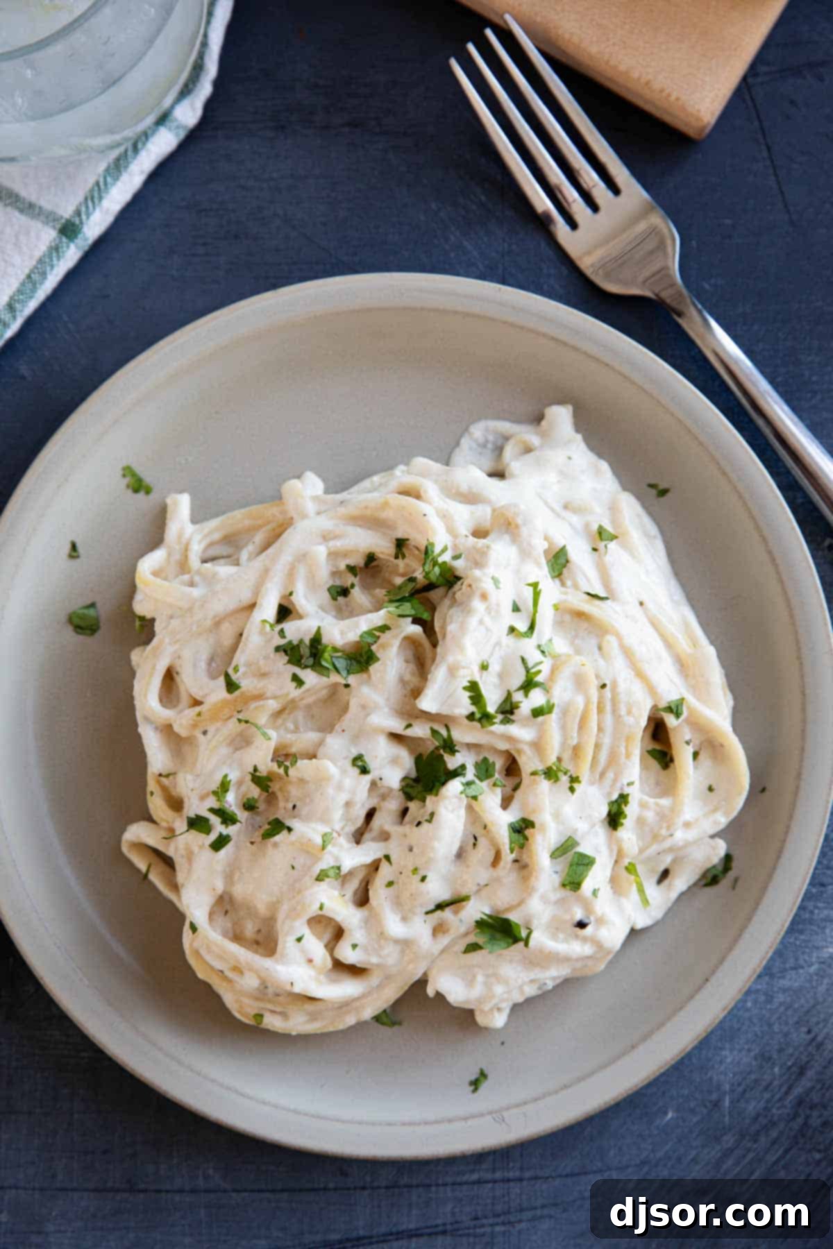 Slow cooker chicken alfredo with fettuccine noodles on a plate.