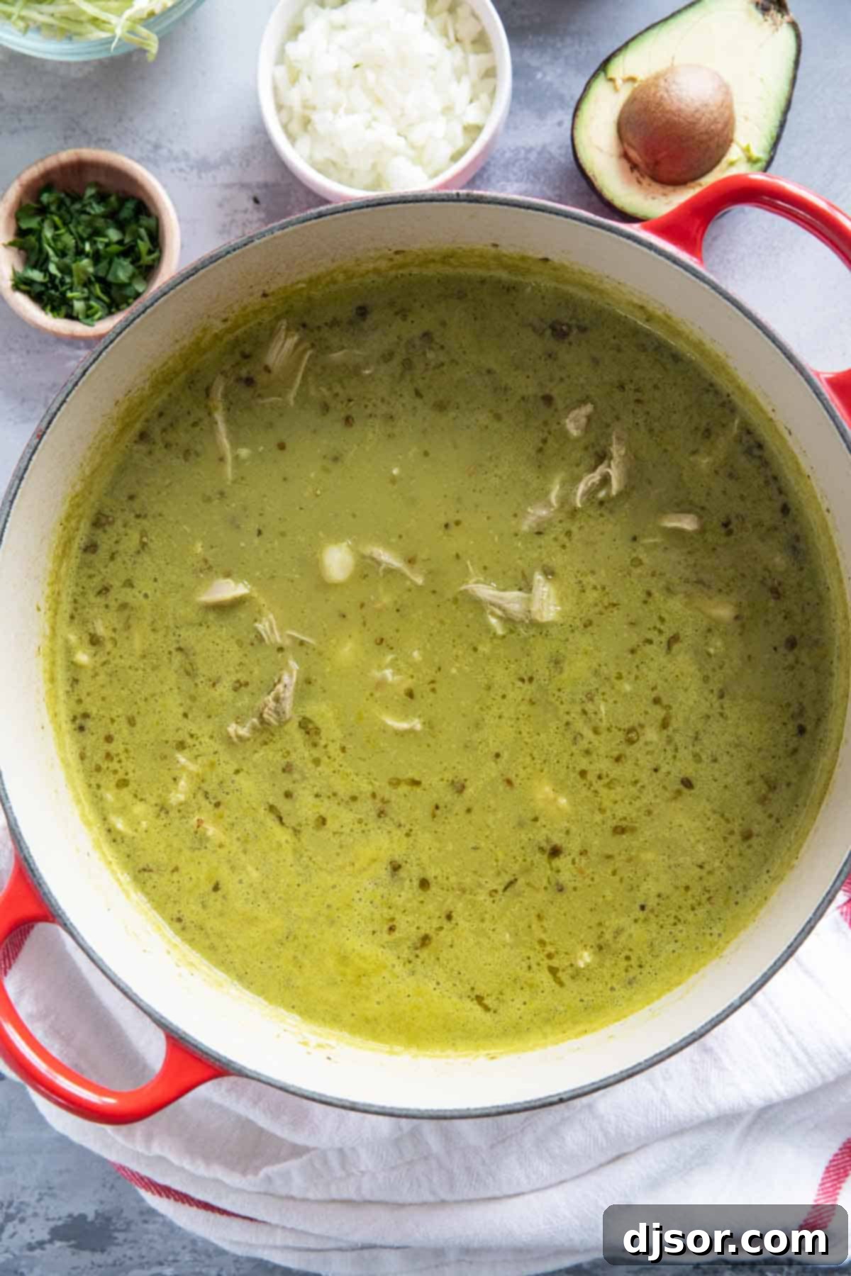 Zesty Green Pozole 8 A large soup pot filled with a rich, vibrant green Pozole Verde, showing the shredded chicken and hominy submerged in the broth, ready to be served.