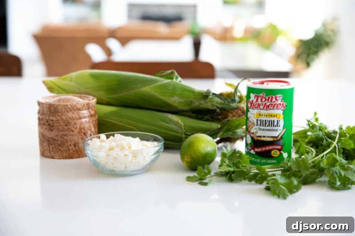 Take advantage of sweet summer corn with this Mexican Corn Salad - filled with Mexican cheese, lime, cilantro and a zing of spiciness. Ingredients laid out for Mexican Corn Salad preparation, including fresh corn, a lime, cilantro, and Cotija cheese.