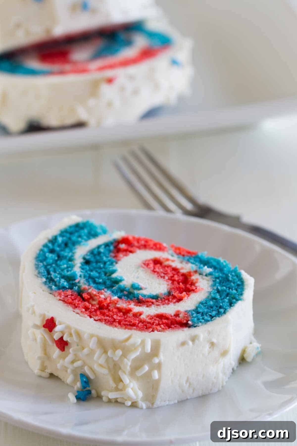 Slice of 4th of July Cake Roll showing a vibrant red, white, and blue swirl interior
