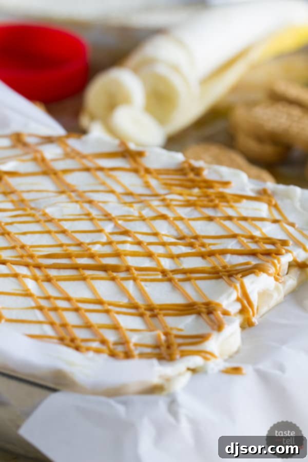 A close-up shot of a slice of Peanut Butter Banana Icebox Cake, revealing its distinct layers of softened peanut butter cookies, rich peanut butter mousse, and fresh banana slices, ready to be enjoyed.
