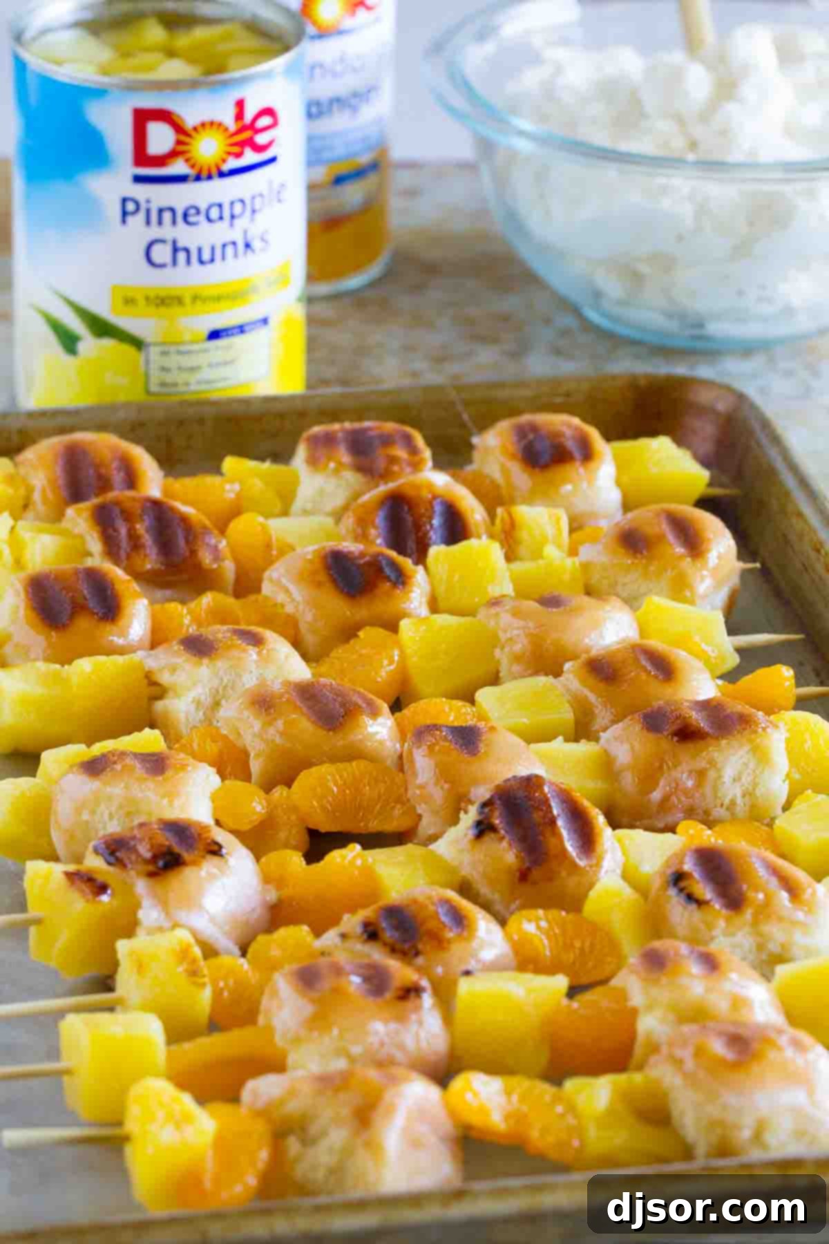 Grilled Kabobs: Donuts, Pineapple, and Oranges Close-up of freshly grilled kabobs, alternating between glazed donut holes, succulent pineapple, and sweet mandarin oranges, showcasing their golden hue and slight char.