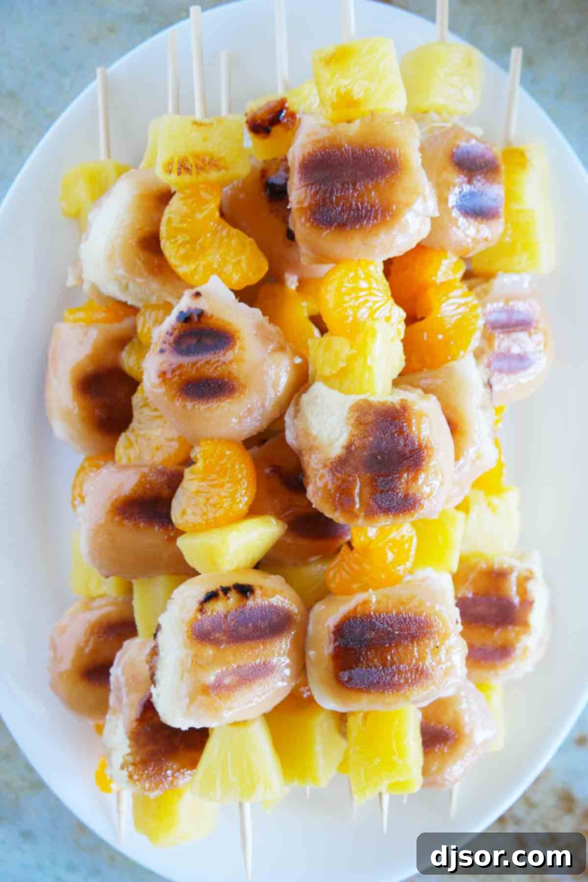 Stacked Grilled Donut and Fruit Kabobs A stack of golden-brown Grilled Donut and Fruit Kabobs artfully arranged on a white plate, ready to be enjoyed with the accompanying Mascarpone Cream.