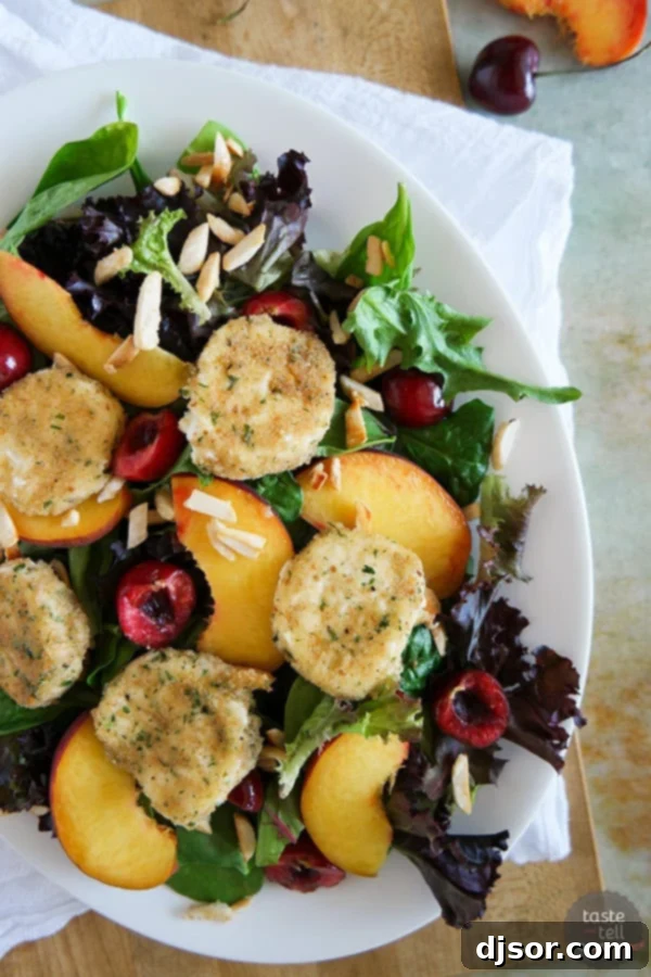 Delicious Stone Fruit and Fried Goat Cheese Salad Ready to Enjoy Close-up of a refreshing summer salad featuring mixed greens, sliced peaches, pitted cherries, and golden fried goat cheese rounds.