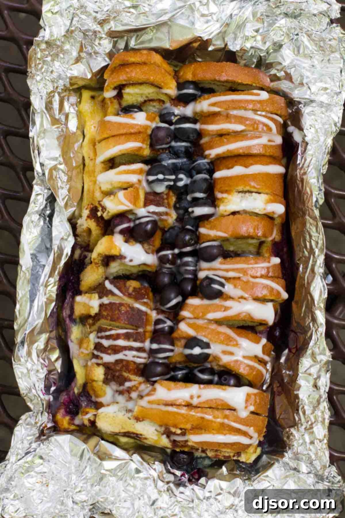 view of campfire cinnamon blueberry bread topped with glaze and blueberries.