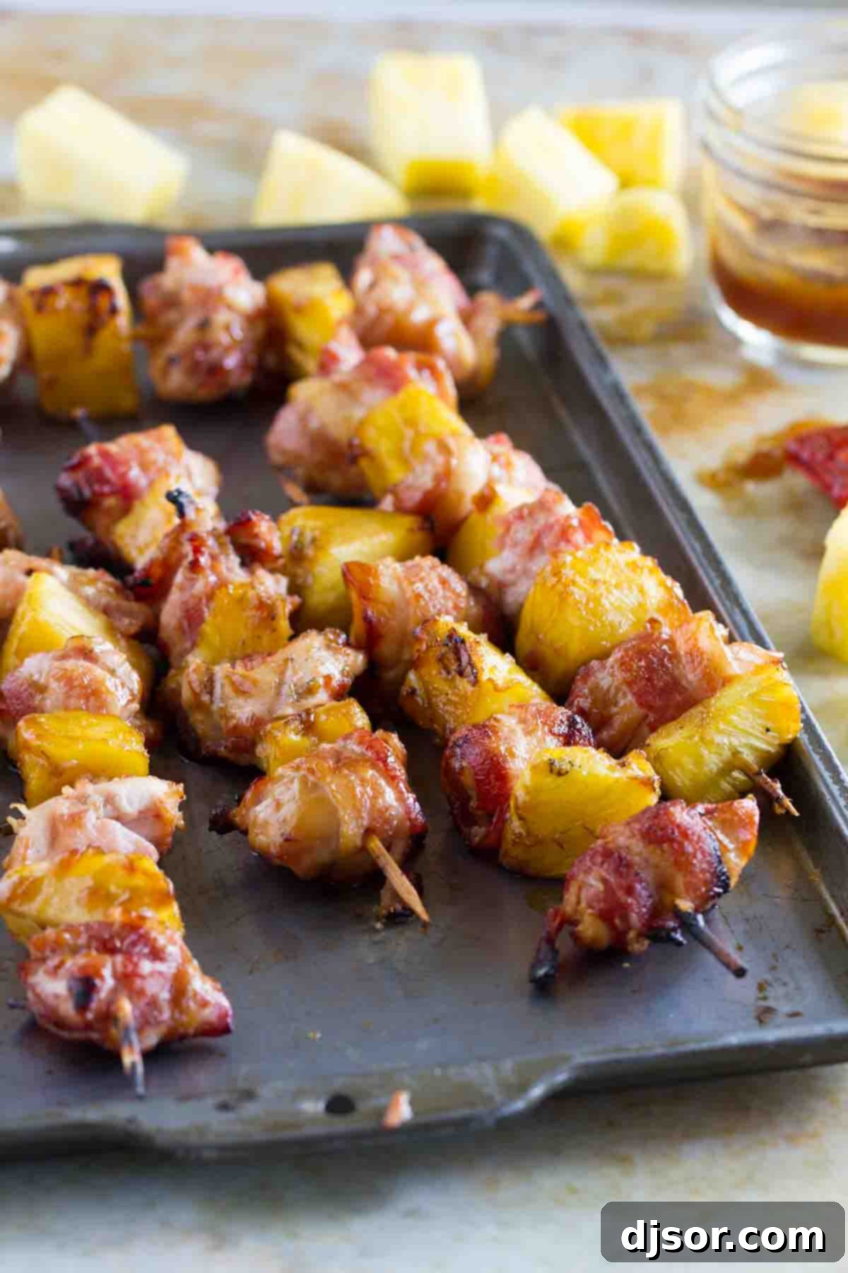 Delectable Bacon Wrapped Teriyaki Chicken Skewers resting on a baking sheet, ready for the grill, showcasing vibrant colors and preparation.