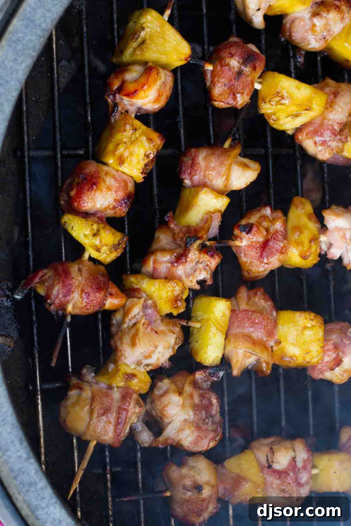Bacon Wrapped Teriyaki Chicken Skewers cooking perfectly on a hot grill, with visible char marks and sizzling juices.