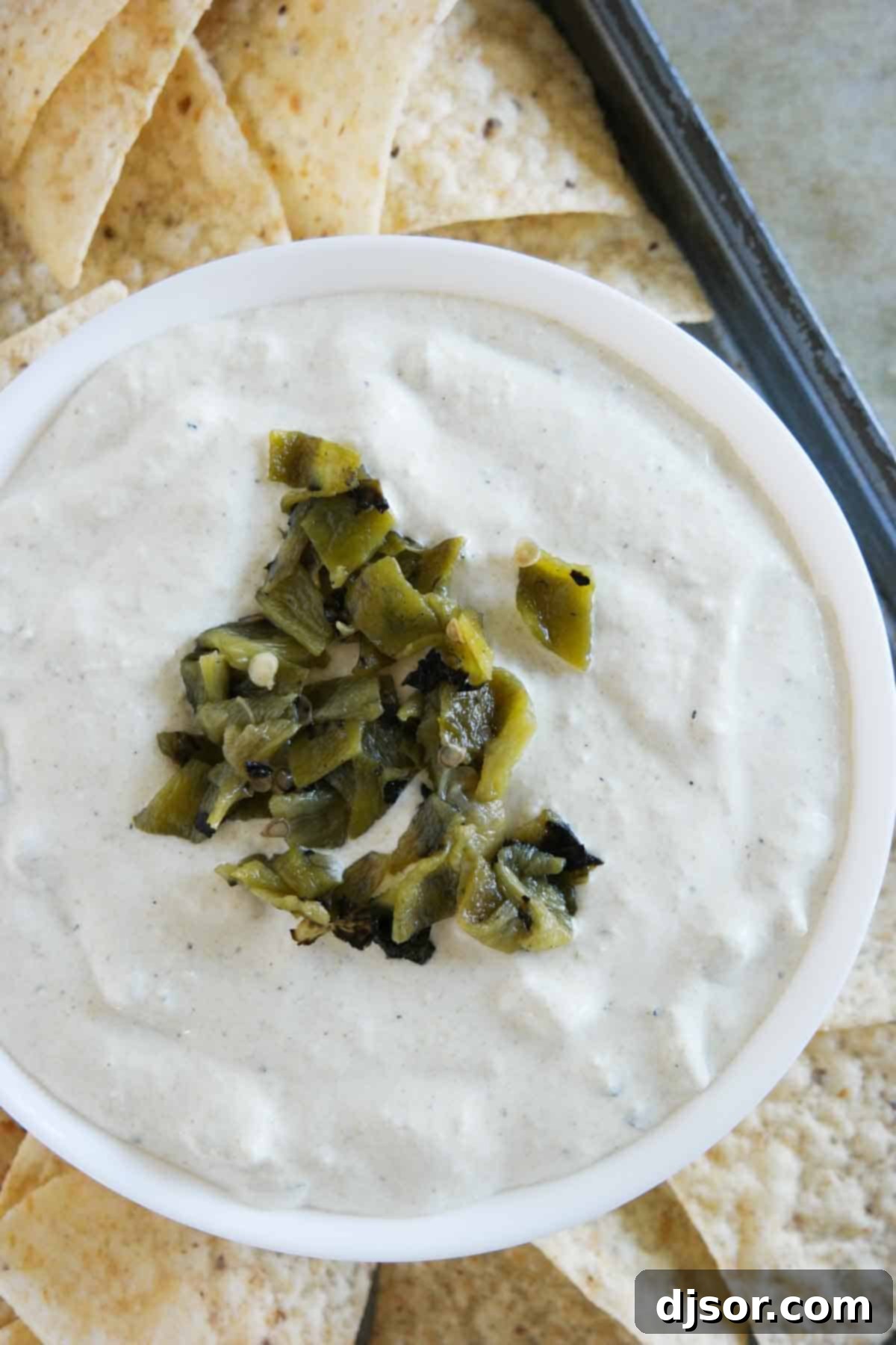 Creamy Hatch Green Chile Dip, perfectly arranged with a generous supply of tortilla chips overhead view of green chile dip surrounded by chips