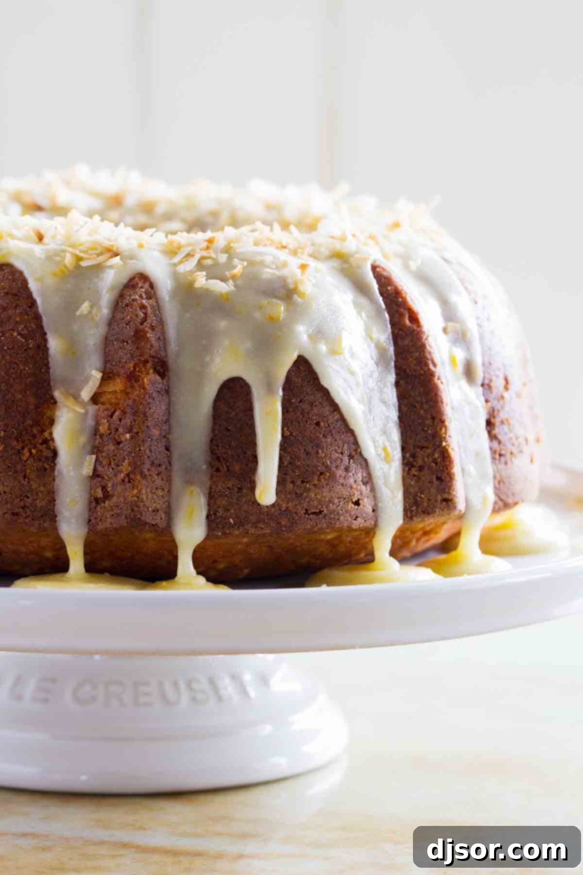 Coconut Orange Pound Cake with tropical flavors A stunning Coconut Orange Pound Cake, beautifully glazed and garnished, resting on an elegant cake plate.