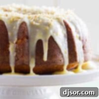 Zesty Coconut Orange Pound Cake 2 Coconut Orange Pound Cake with icing on a cake plate.