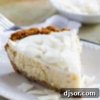Slice of Coconut Cheesecake Pie on a plate, featuring the golden crust and creamy filling.