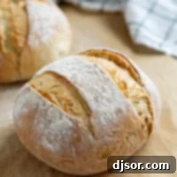 No Knead Crusty Artisan Bread 11 Two loaves of artisan bread on parchment paper.