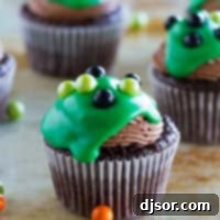Ultimate Chocolate Cupcakes topped with green ganache and candy balls.