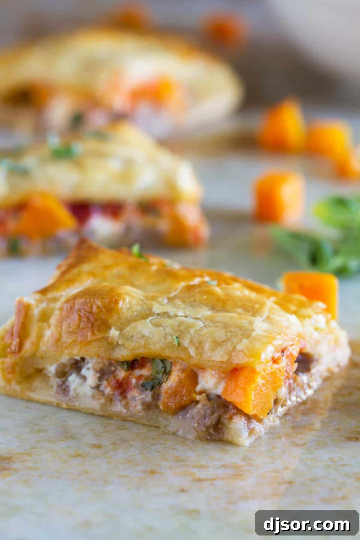 A perfectly baked slice of Sausage and Butternut Squash Slab Pie, showcasing the flaky crust and savory filling.