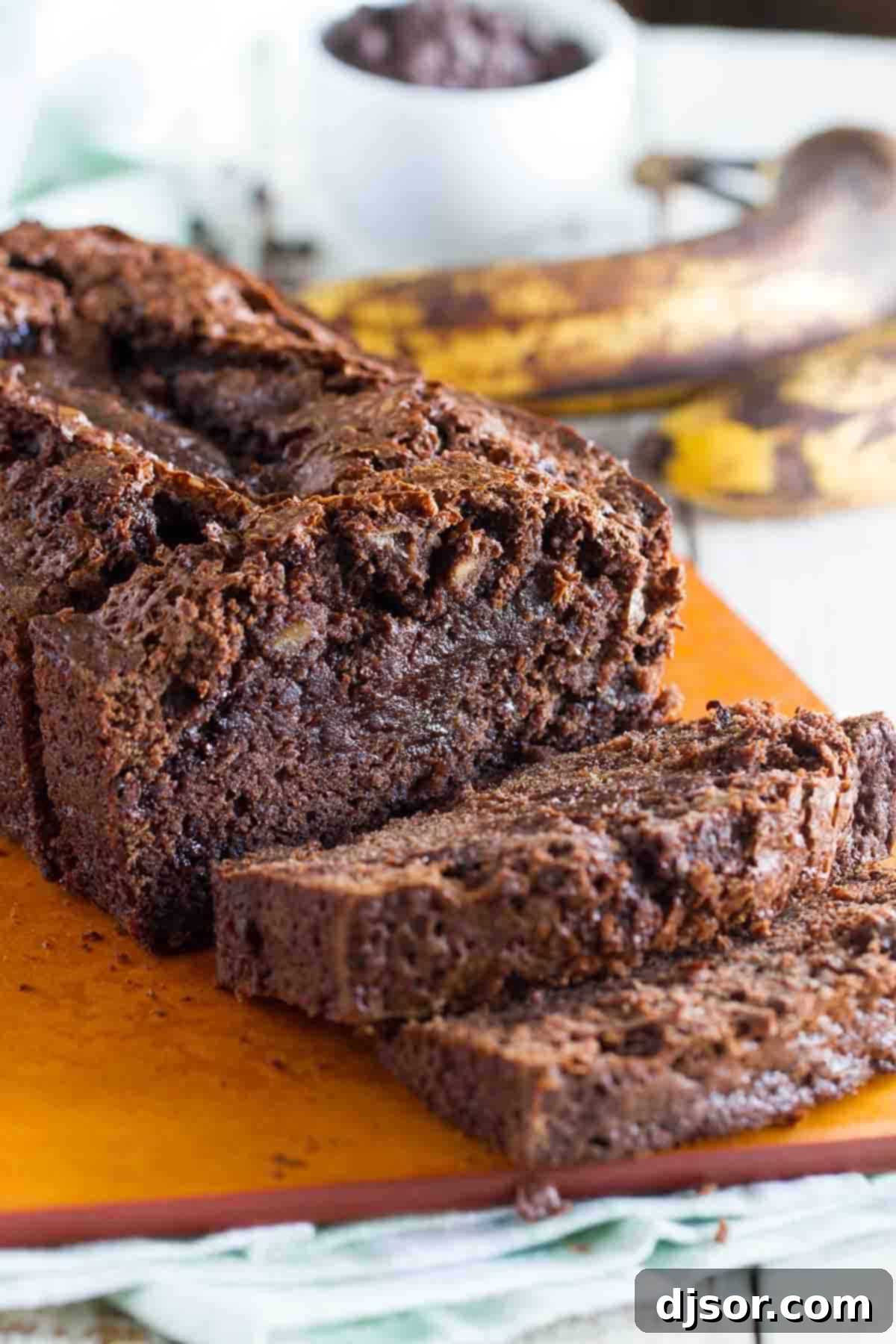 A perfectly baked loaf of Brownie Mix Banana Bread on a rustic cutting board, ready to be sliced.