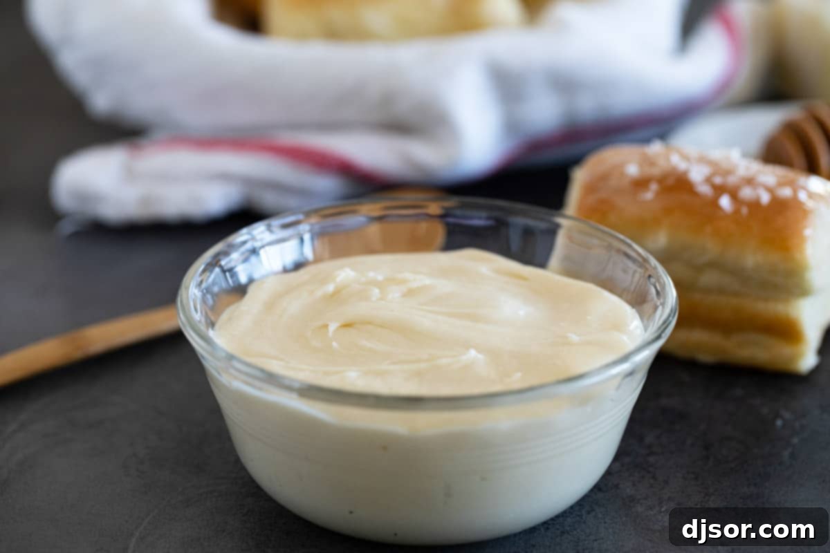 Perfect for slathering on homemade biscuits or rolls, this Honey Butter is going to be something that you always want in your refrigerator. Small bowl filled with Honey Butter.