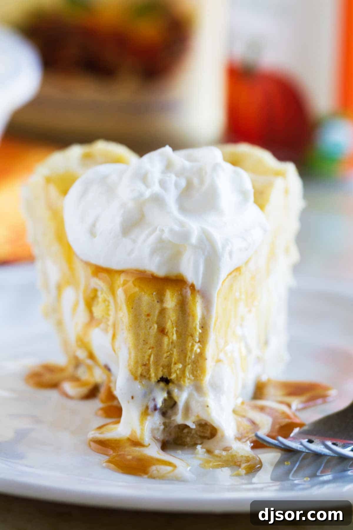 Creamy Autumn Delight Pumpkin Butter Pecan Ice Cream Pie 4 A delectable slice of Pumpkin and Butter Pecan Ice Cream Pie, with a small bite already taken, showcasing its creamy layers and inviting texture. The plate is clean, highlighting the dessert itself as the star.