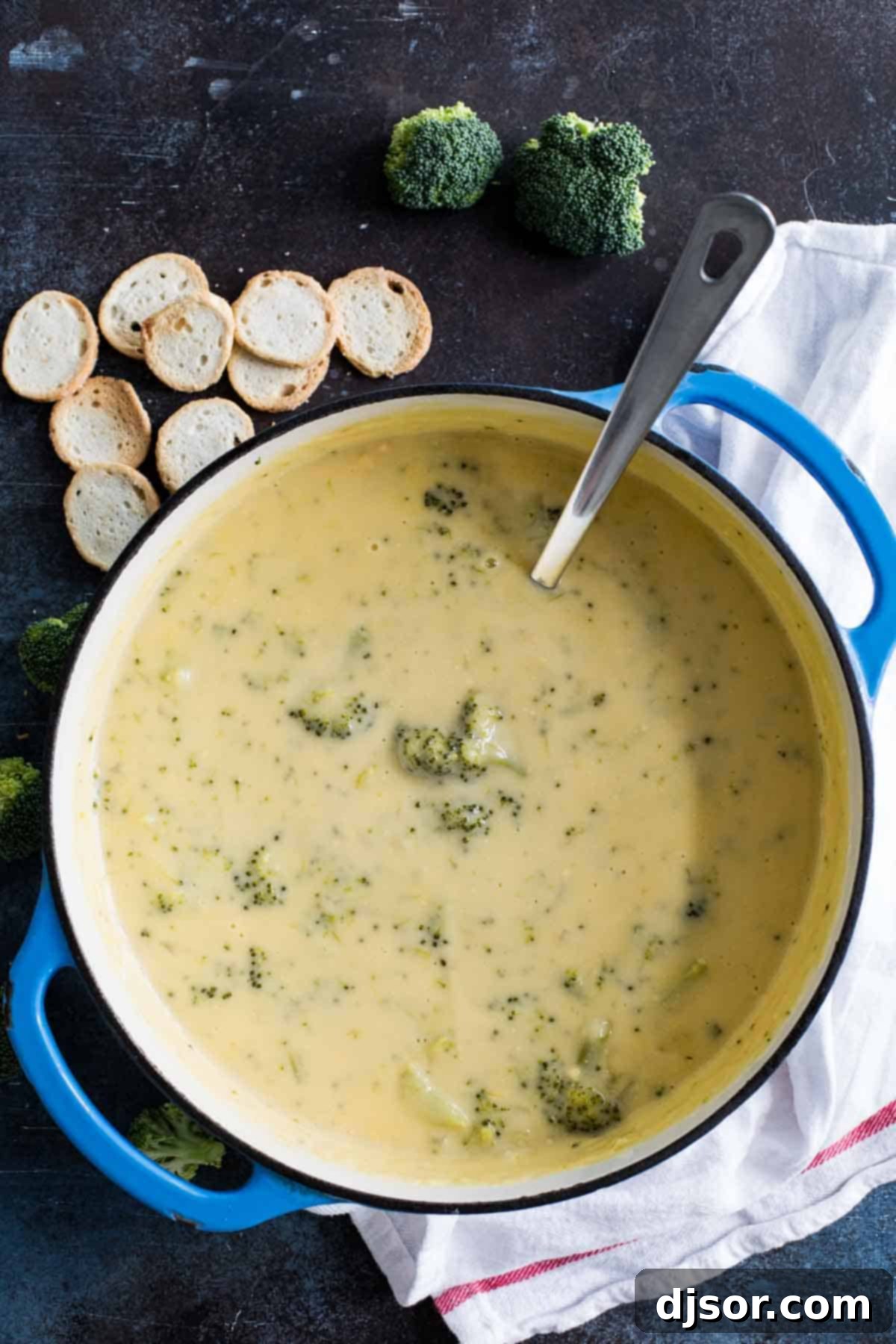 Overhead shot of a pot of creamy broccoli cheese soup, steaming and ready to be served.