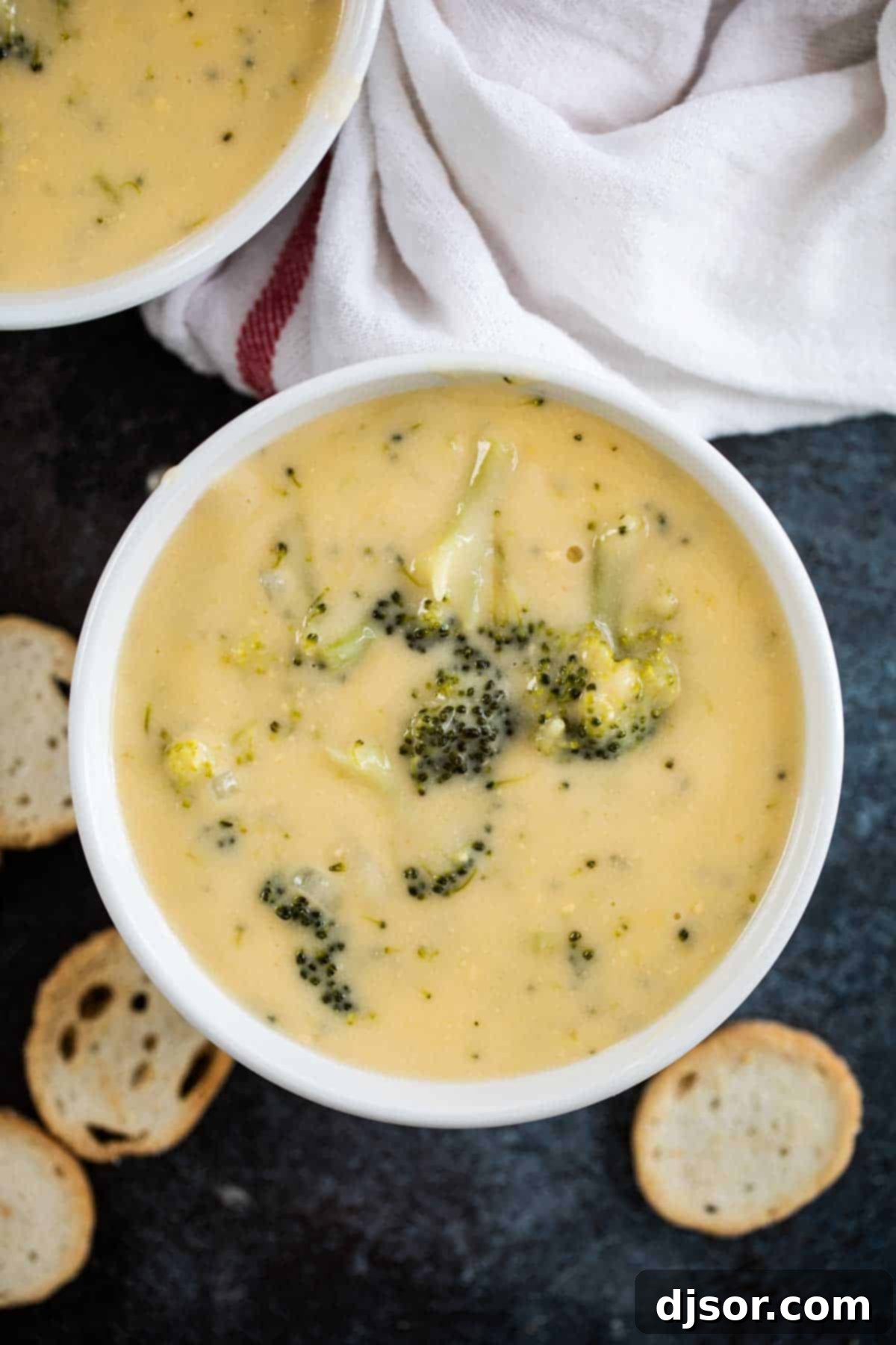 A close-up of a bowl of creamy homemade Broccoli Cheese Soup, garnished and ready to be enjoyed.