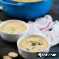 Two bowls of broccoli cheese soup with a pot in the back