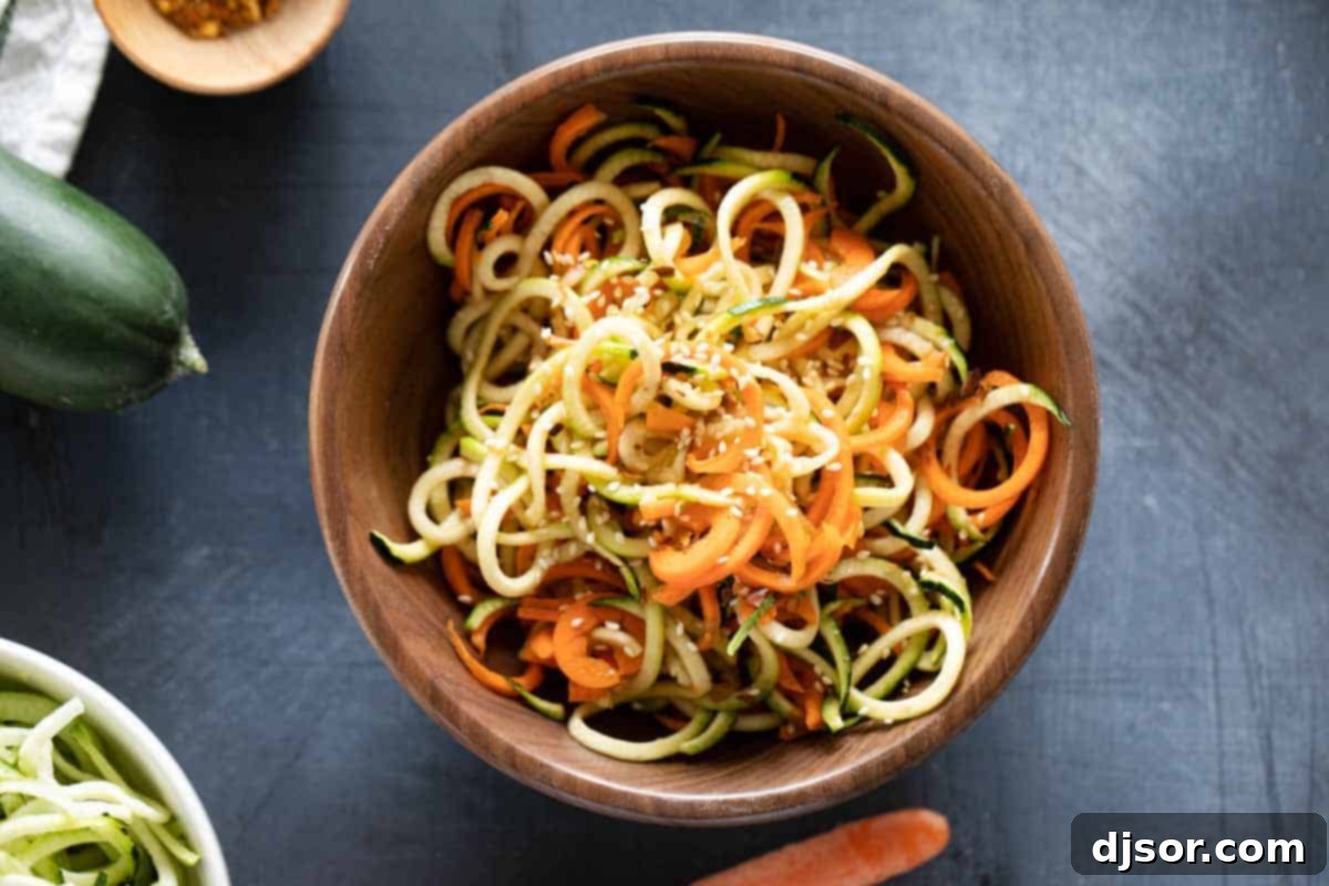A beautiful wooden bowl filled with a fresh Korean Cucumber Salad, showcasing the spiralized texture of cucumbers and carrots, garnished with sesame seeds.