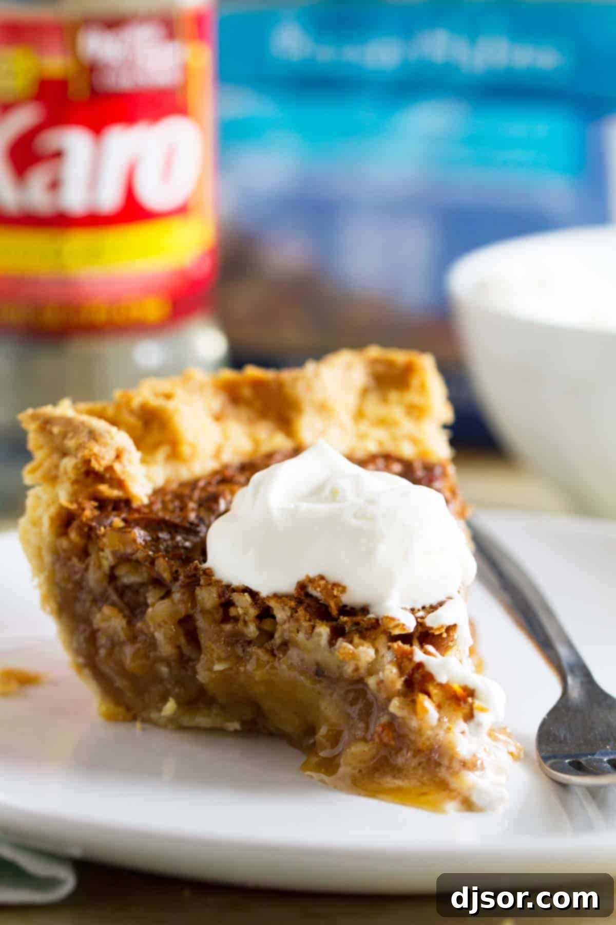 Slice of coconut pecan pie topped with whipped cream.