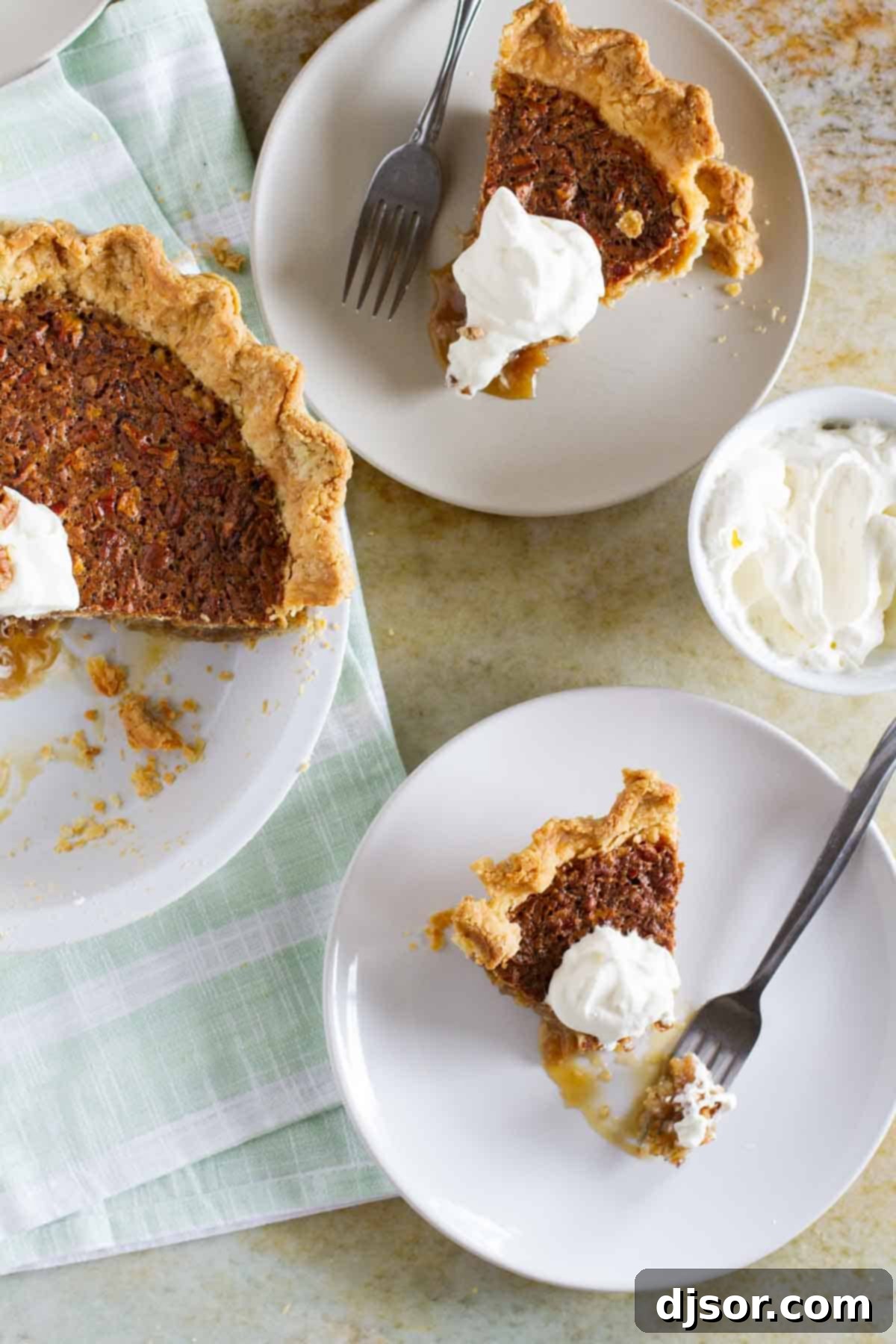 Slices of coconut pecan pie on plates, topped with whipped cream.