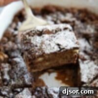 A scoop of rich chocolate bread pudding garnished with fresh whipped cream, ready for serving.
