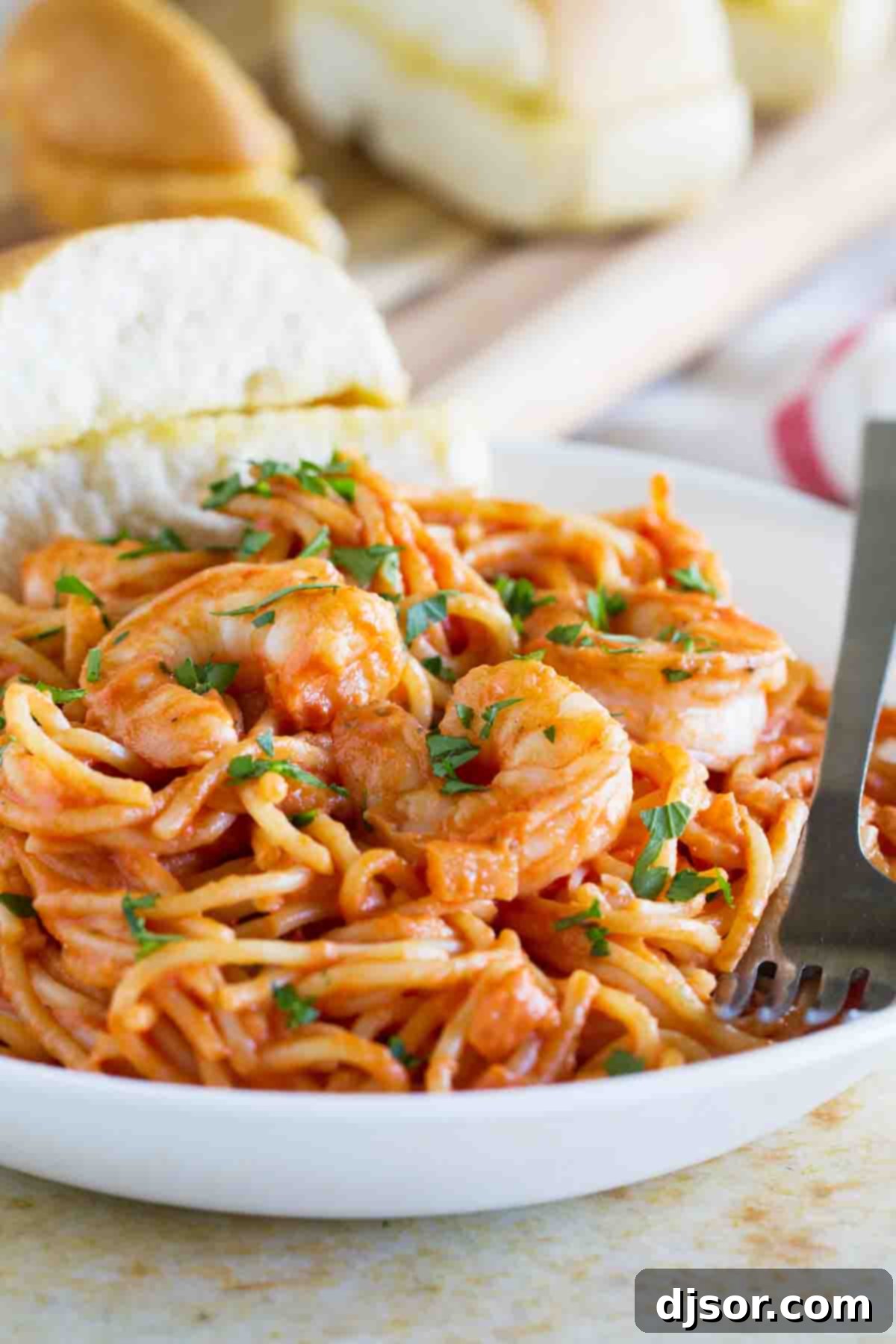 Luscious Creamy Shrimp and Tomato Pasta 2 Serving of Creamy Shrimp and Tomato Pasta with garlic bread, garnished with fresh parsley.
