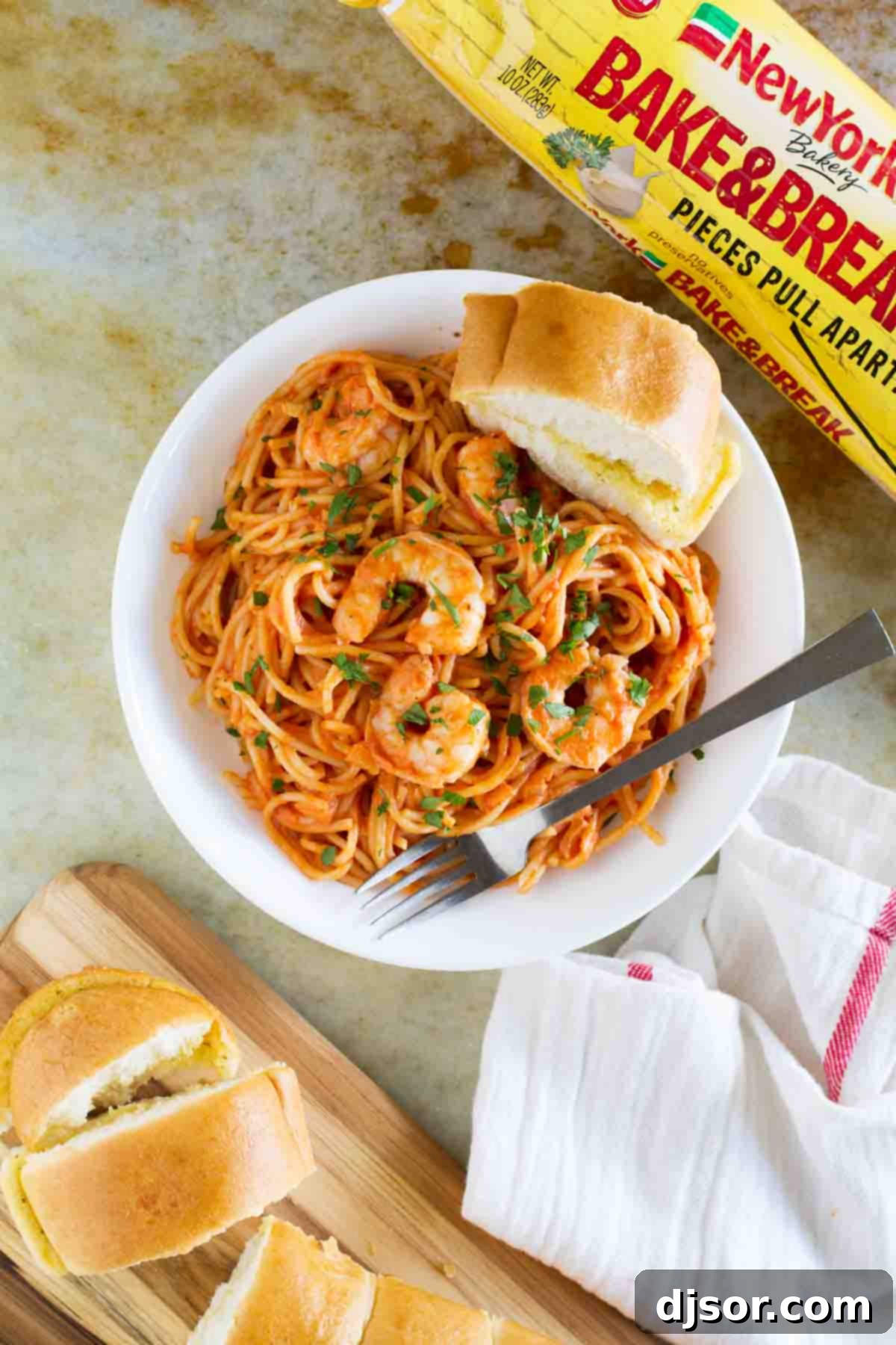 Luscious Creamy Shrimp and Tomato Pasta 4 Creamy Shrimp and Tomato Pasta served in a bowl with garlic bread and fresh herbs.