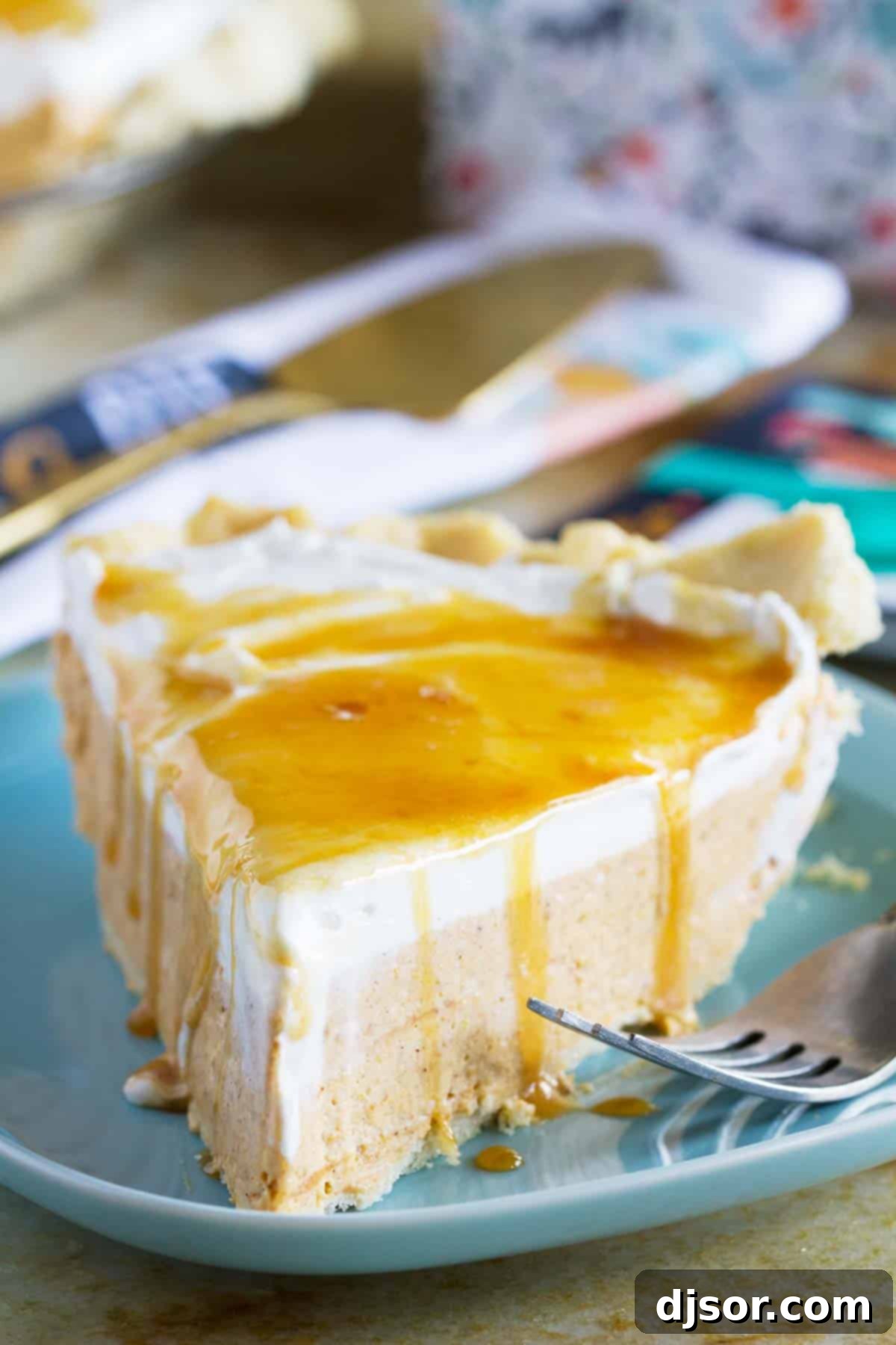 A perfectly sliced piece of creamy White Chocolate Caramel No Bake Pumpkin Pie on a rustic plate with a fork, ready to be enjoyed.