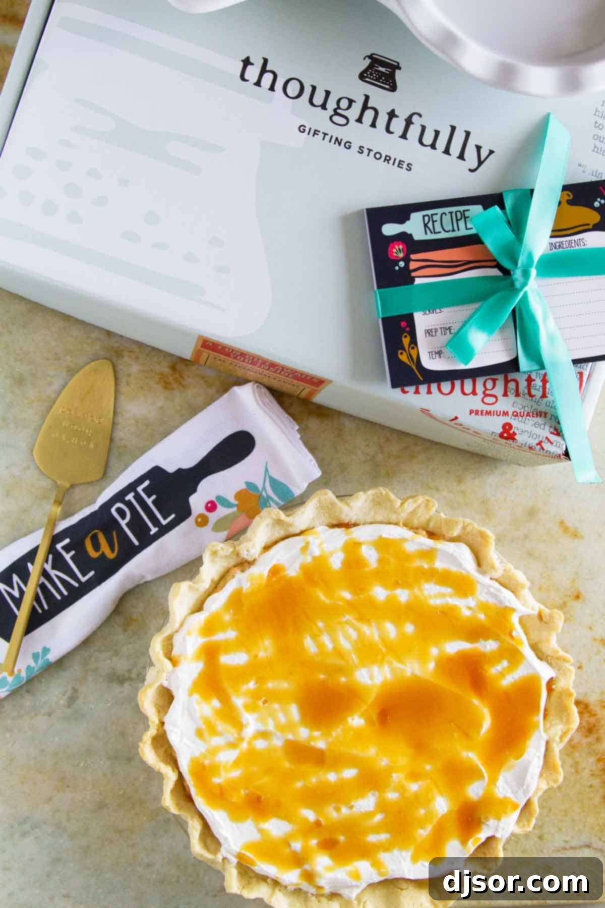 A delectable White Chocolate Caramel No Bake Pumpkin Pie, artfully arranged with elegant Thoughtfully gift box components in the background.