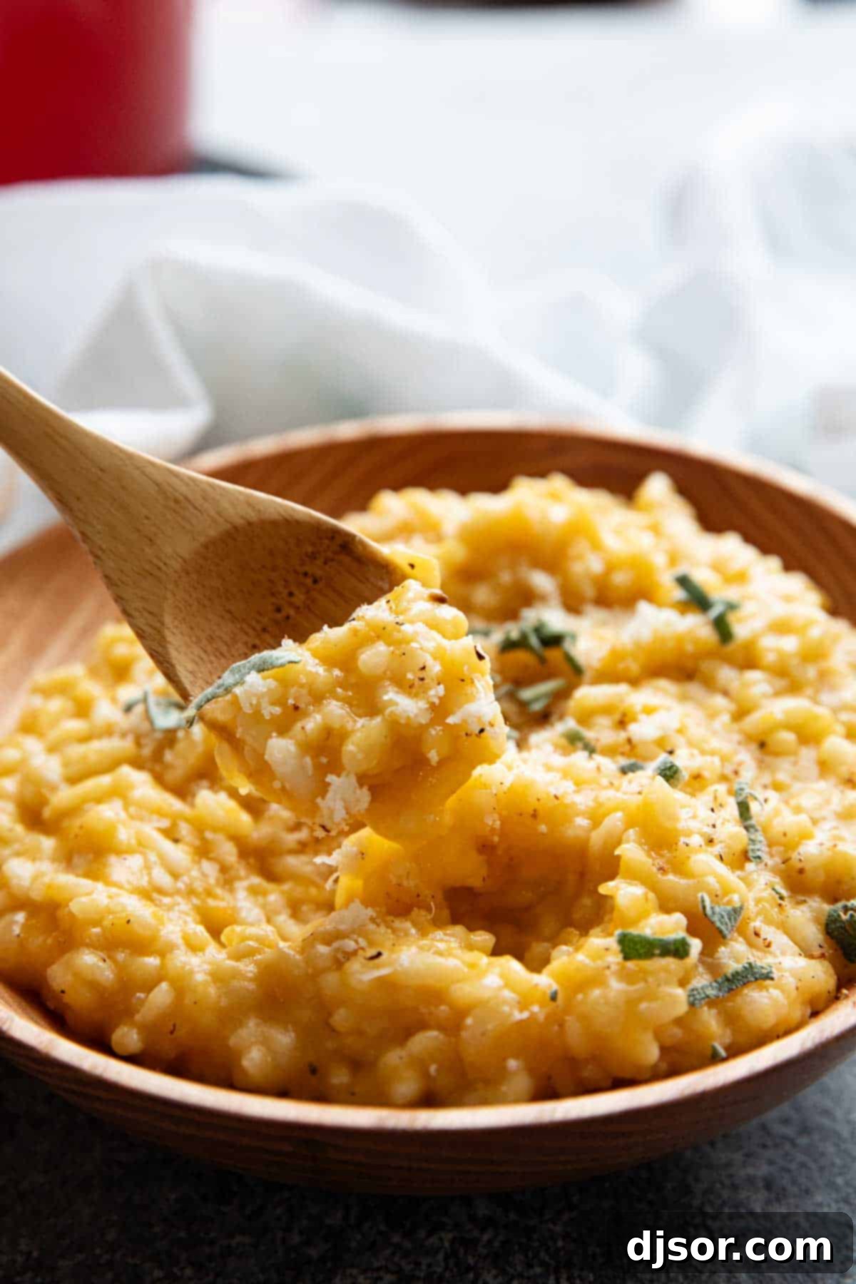 Golden Butternut Risotto 9 A close-up of creamy butternut squash risotto served in a wooden spoon, showcasing its rich texture.