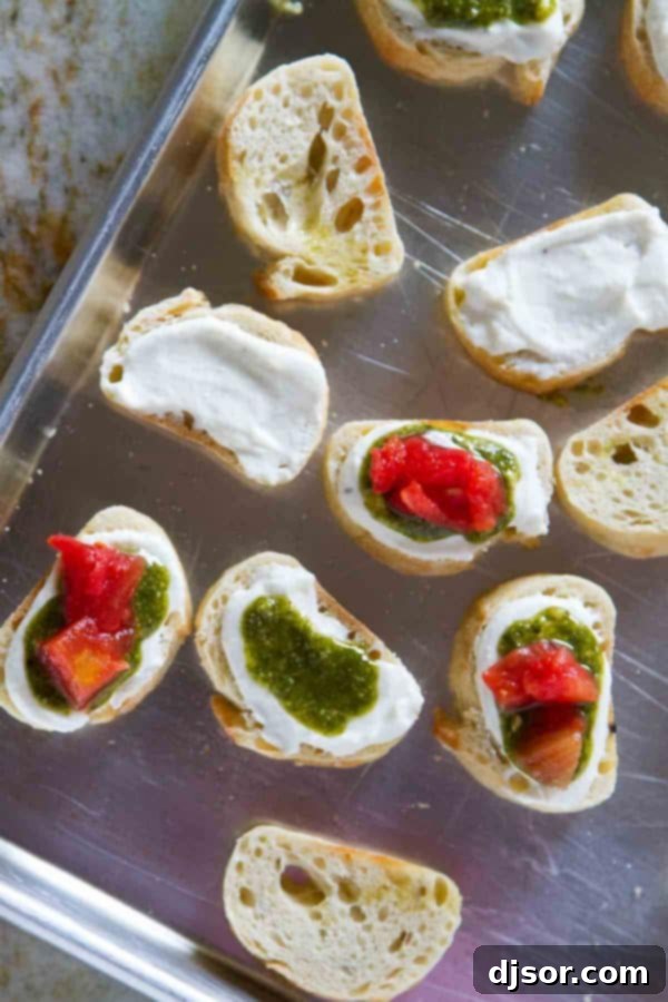 Vibrant Feta, Pesto, and Tomato Bruschetta 4 A plate of freshly prepared Feta Pesto Tomato Bruschetta, ready to be served as an elegant appetizer.