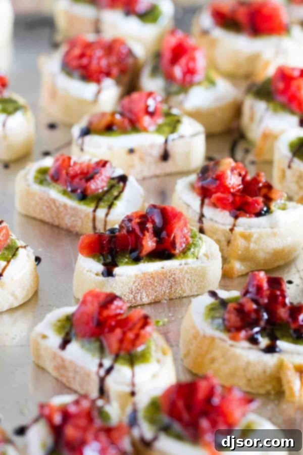 Vibrant Feta, Pesto, and Tomato Bruschetta 6 A serving of Feta Pesto Tomato Bruschetta with a balsamic glaze drizzle, ready for guests.