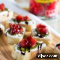 Vibrant Feta, Pesto, and Tomato Bruschetta 7 Feta Pesto Tomato Bruschetta appetizer on a white plate