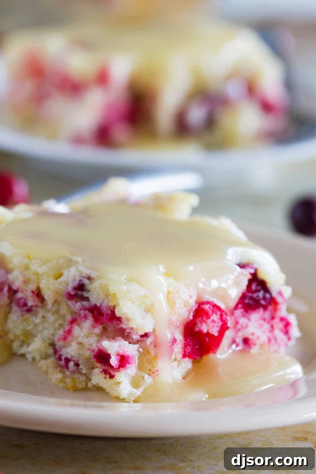 Slice of cranberry cake with warm butter sauce over the top