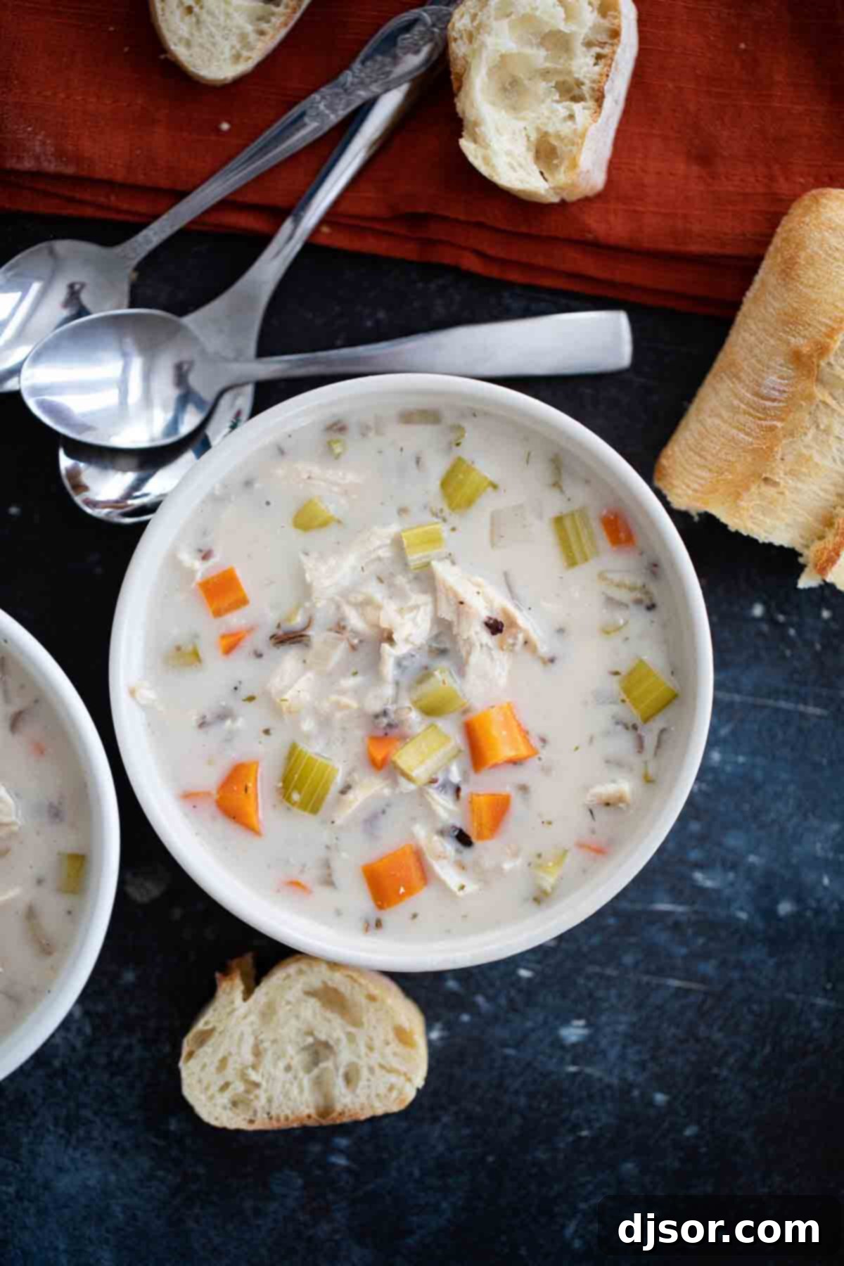 overhead view of a bowl of creamy chicken wild rice soup with fresh herbs