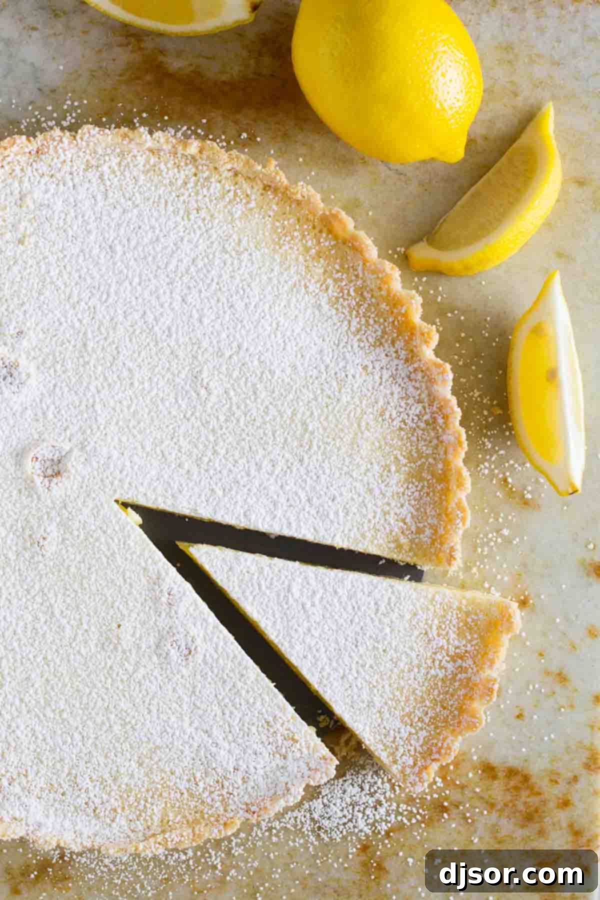 A Shortbread Lemon Tart with a single perfect slice removed, revealing the smooth, sun-yellow filling and the crisp, golden crust beneath.