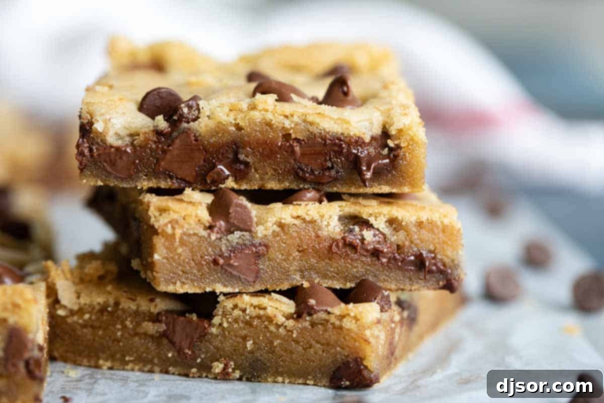 A close-up of a cut Chocolate Chip Cookie Bar, revealing its incredibly moist interior and melted chocolate chips, highlighting its soft texture.