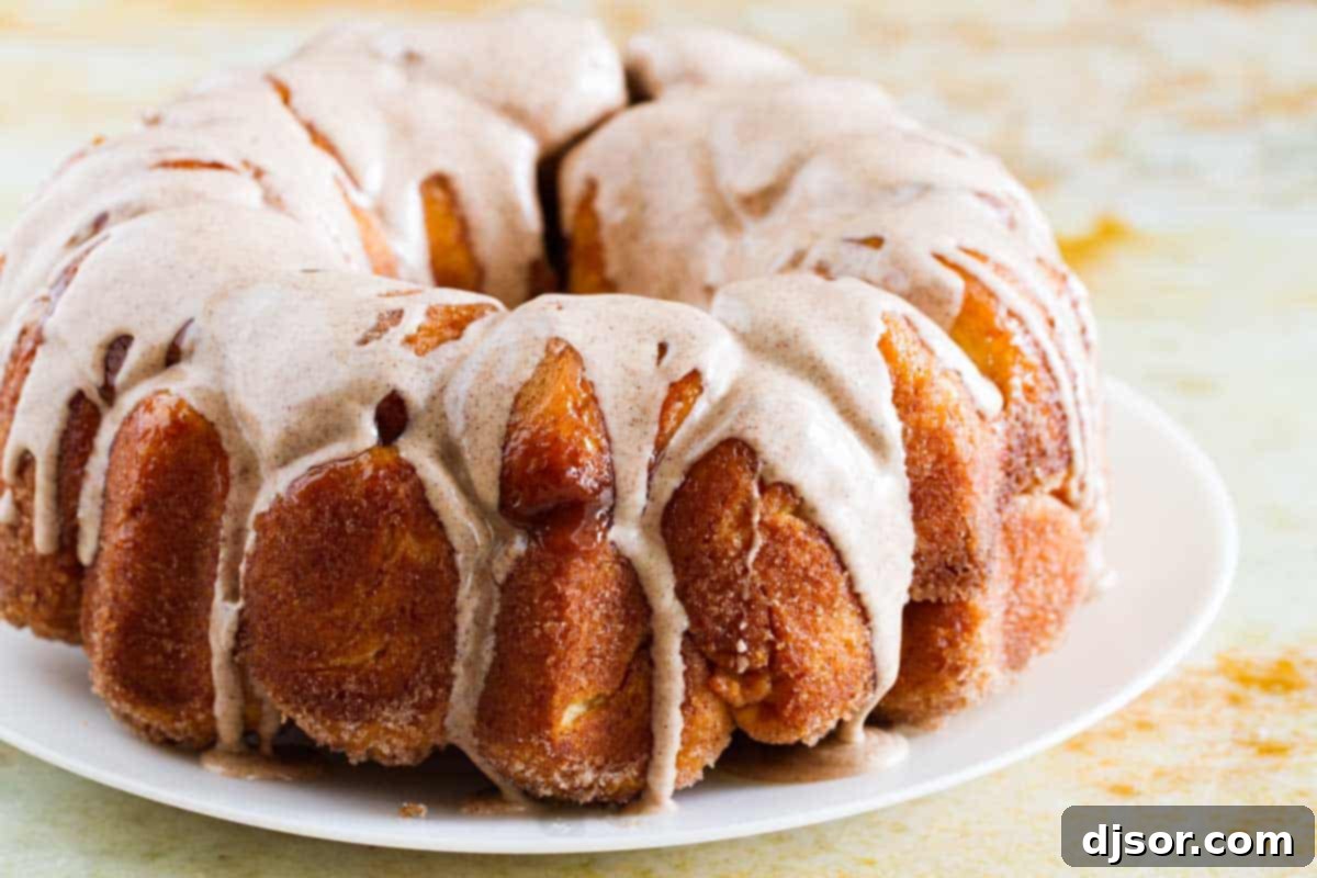 Homemade Monkey Bread with Cinnamon Glaze Close-up of golden-brown Monkey Bread with a glistening cinnamon glaze, served on a white plate