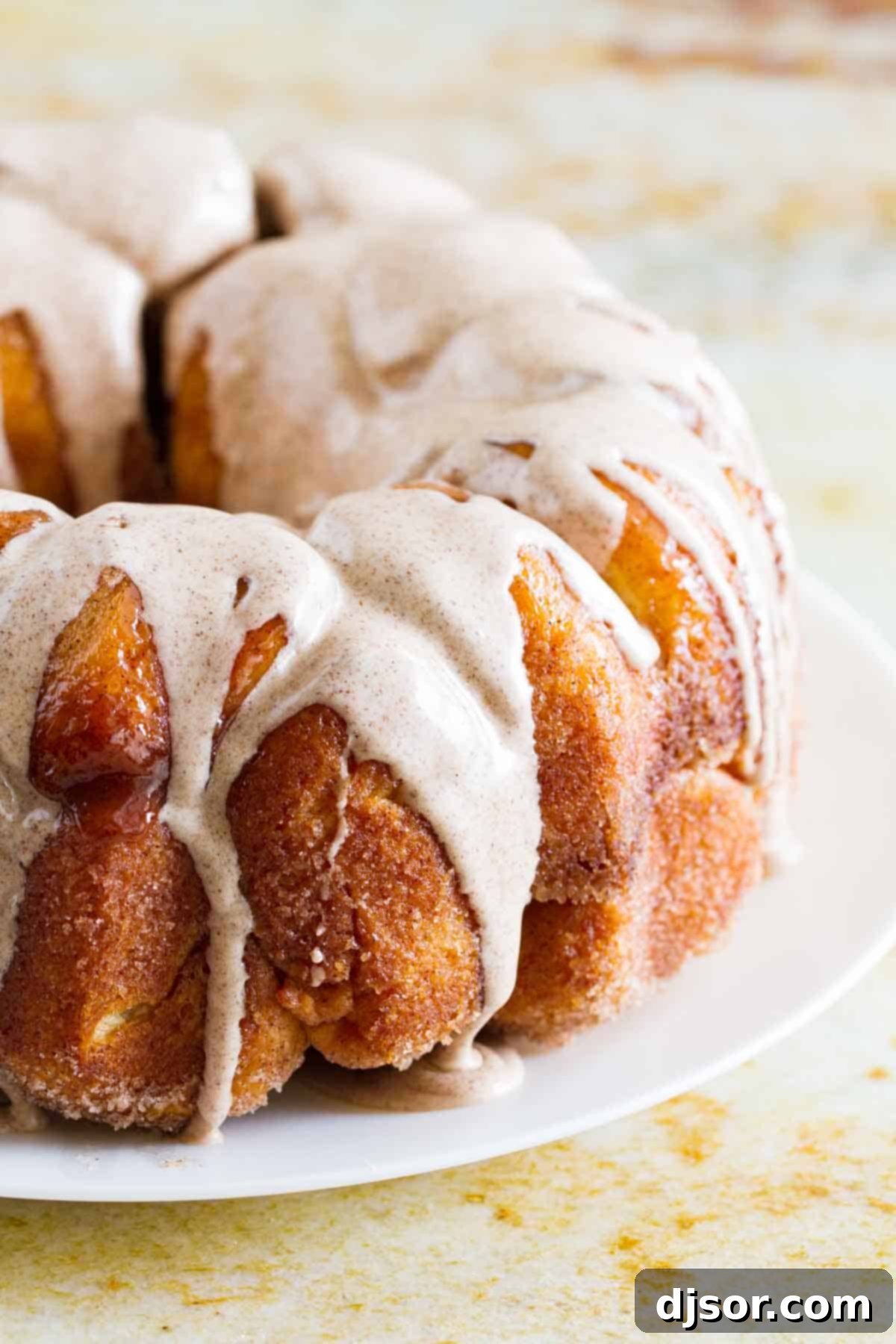 Homemade Monkey Bread 2 Finished Monkey Bread with white cinnamon icing on a white plate, ready to be served