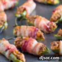 Spicy Bacon Taco Bombs 2 bacon wrapped jalapeno poppers with taco filling on a baking sheet