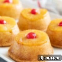 Golden Pineapple Gems 2 Pineapple upside down cupcakes on a tray topped with cherries.