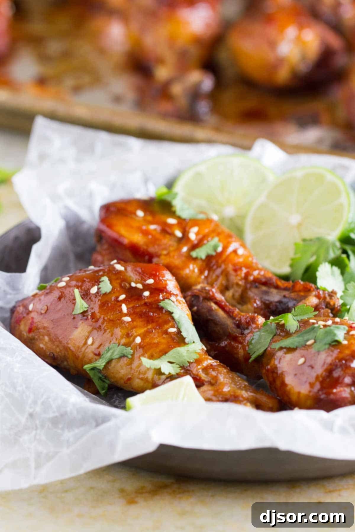 Practically dump and cook, these Slow Cooker Sweet Chili Chicken Drumsticks are full of Asian flavor and the slow cooker makes them easy as can be. Juicy Slow Cooker Sweet Chili Chicken Drumsticks garnished with fresh cilantro and a lime wedge.