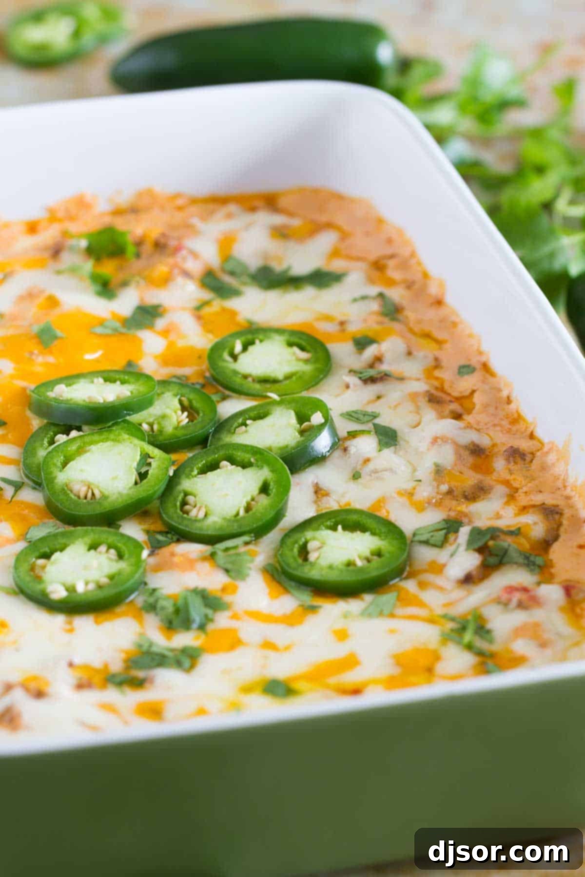 Kickin' Sausage Dip 4 Spicy Sausage Dip, freshly baked and topped with melted cheese and vibrant jalapeño slices.