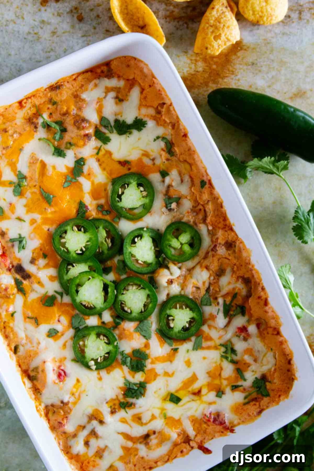 Kickin' Sausage Dip 5 A dish brimming with hot, cheesy spicy sausage dip, generously topped with vibrant fresh jalapeño slices, ready for serving.