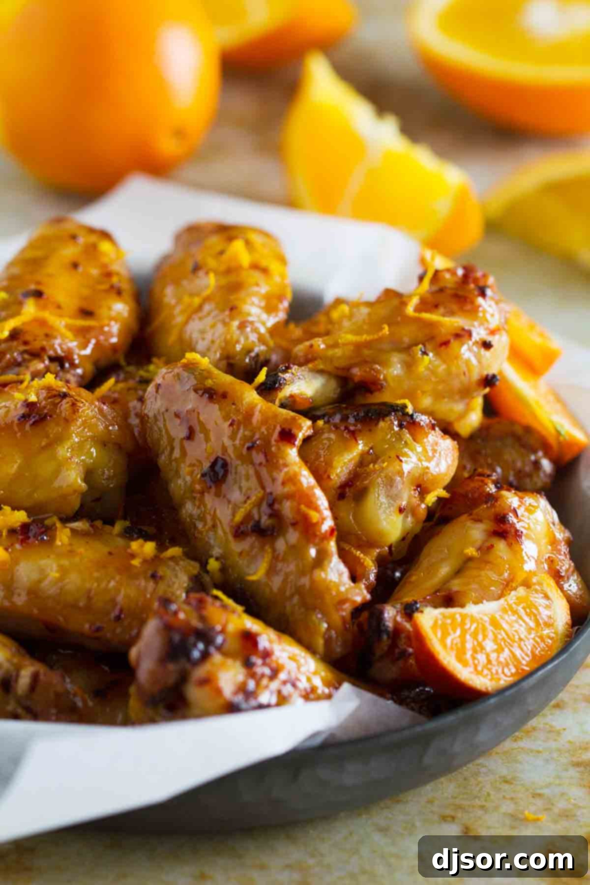 Crispy Chipotle Orange Chicken Wings with a vibrant orange zest garnish, ready to be served.