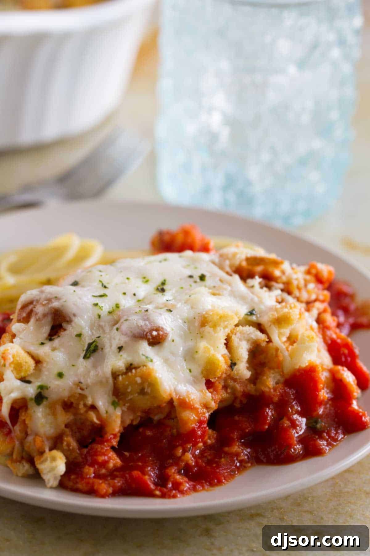 Delicious Chicken Parmesan Casserole, an easier take on the classic dish, served over a bed of spaghetti noodles.
