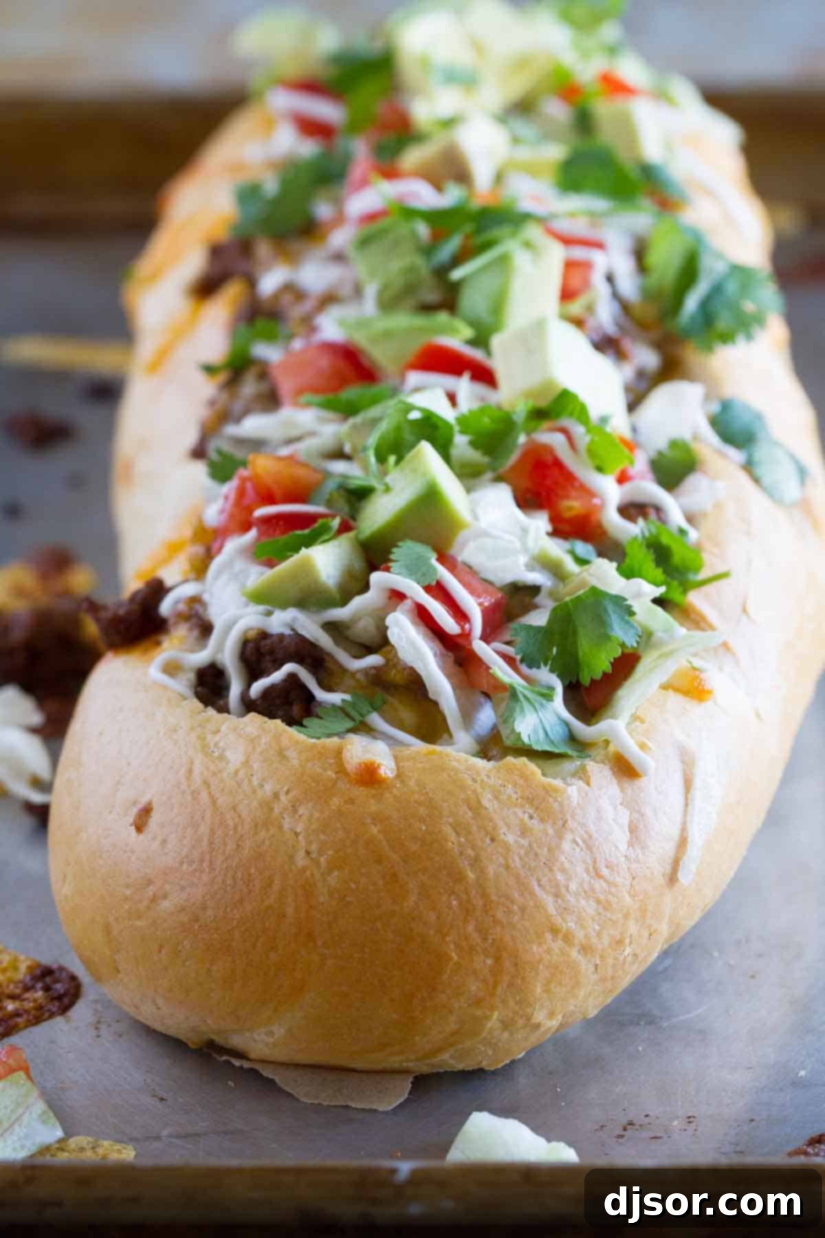 Crispy Taco Pizza Boats 2 A vibrant loaf of Taco French Bread Pizza, generously topped with fresh lettuce, diced tomatoes, and a sprinkle of cilantro, ready to be served.